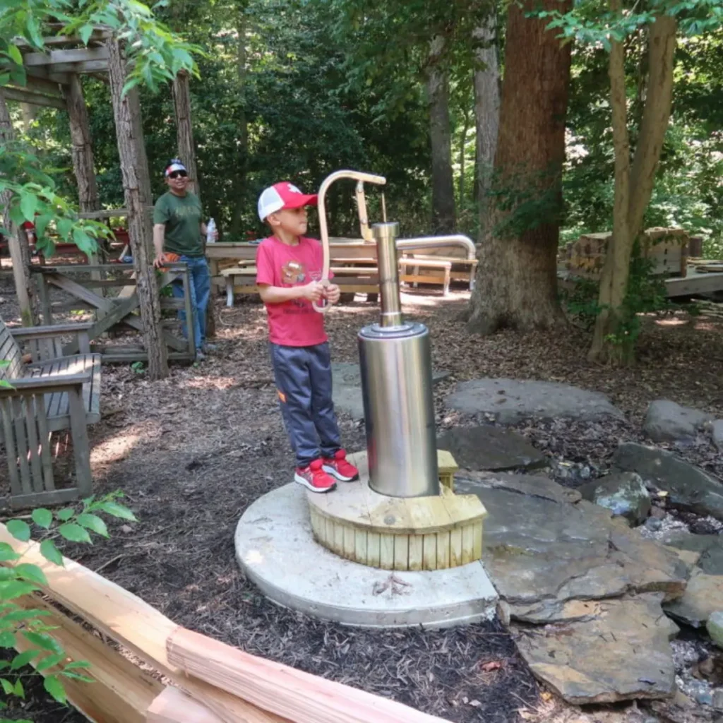 Big Guppy Pump Water Play installation at Hidden Oaks Play Center State Park – interactive stainless steel water play pump.